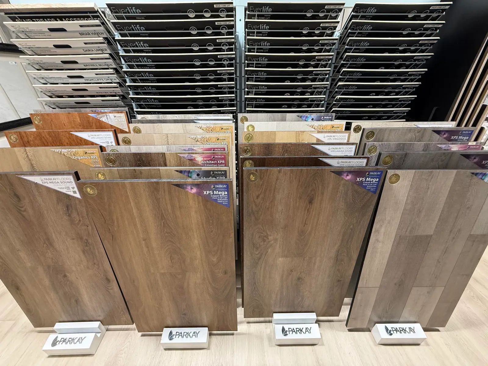 Luxury vinyl plank samples in warm oak tones on a display stand