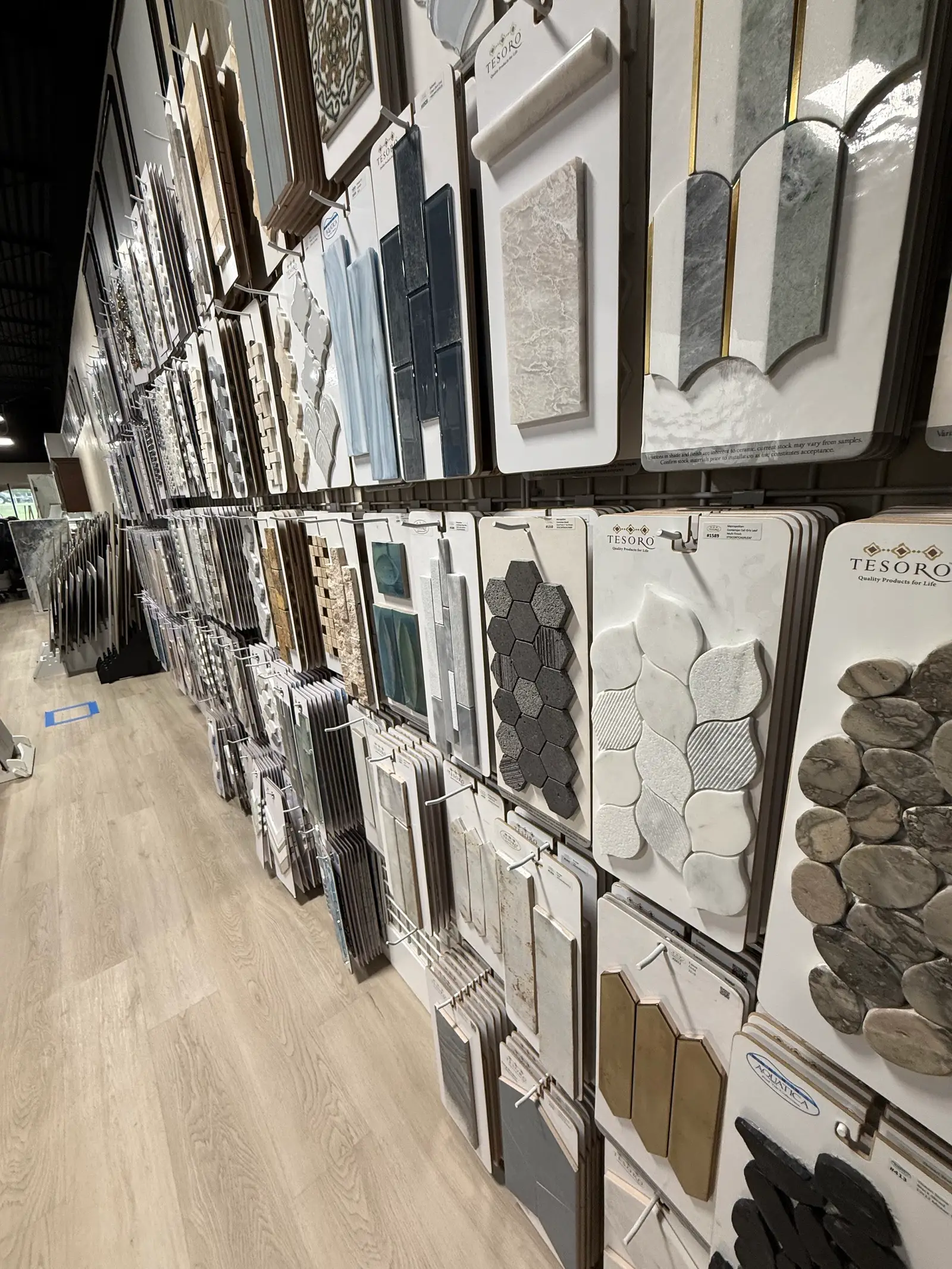 Mosaic and backsplash tile samples on a showroom wall