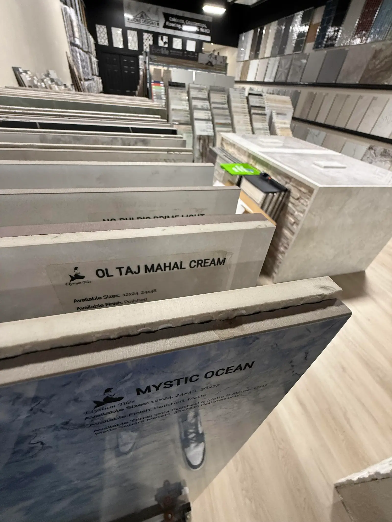 Large porcelain slab samples including Taj Mahal Cream and Mystic Ocean