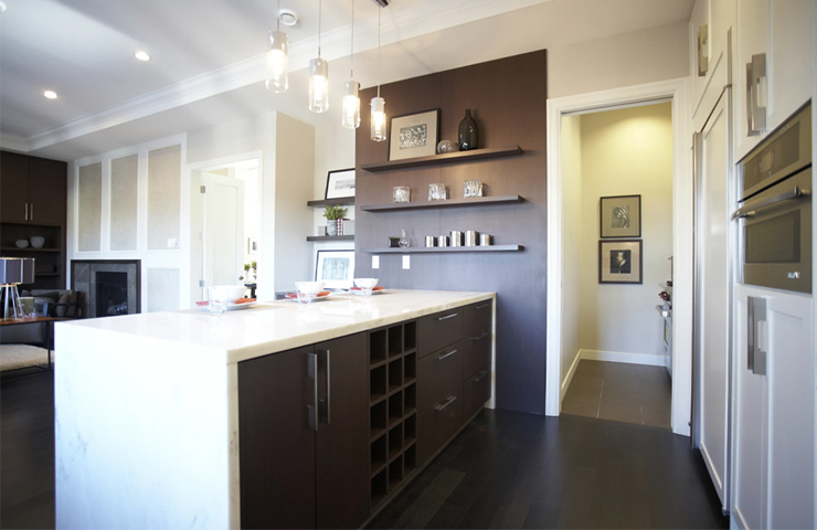 Modern kitchen with dark wood cabinetry, a marble-topped island, pendant lighting, and open shelving. The space has a sleek, minimalist design with neutral tones.